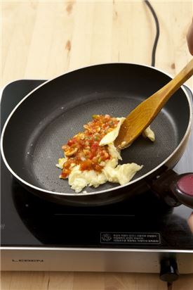 6. 나무주걱을 이용해 달걀을 절반으로 접어 타원형으로 만들고 모차렐라 치즈가 녹으면 그릇에 담는다.