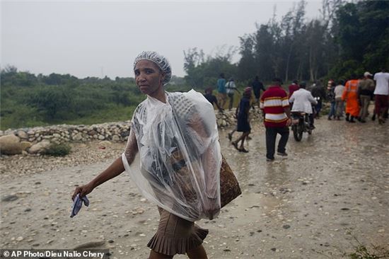 4일 허리케인 매튜가 상륙한 아이티에서 한 여인이 비닐을 뒤집어쓴 채 이동하고 있다. (사진출처=AP)