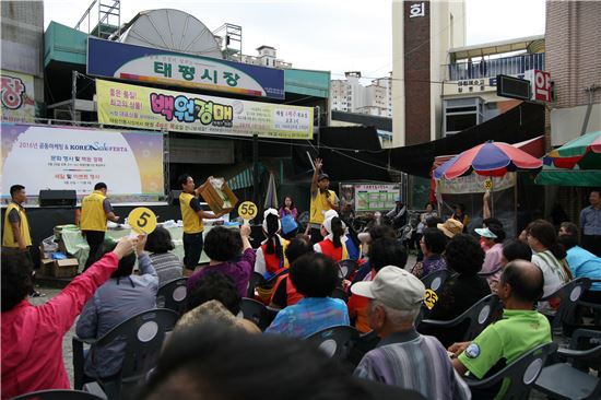 대전 태평시장 상인들과 고객들이'100원 경매' 이벤트에 참여하고 있다. 