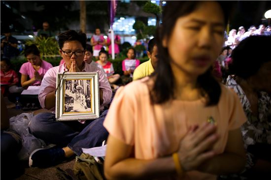 ▲푸미폰 아둔야뎃 태국 국왕이 입원한 방콕 시리라즈 병원 앞에서 시민들이 국왕의 사진을 품에 안고 쾌유를 기원하고 있는 모습(사진=EPA연합뉴스) 
