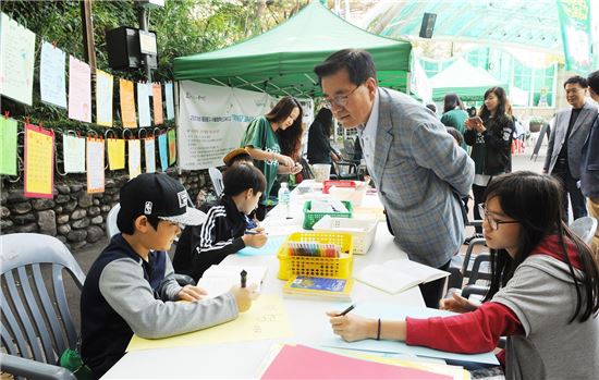 유덕열 동대문구청장이 15일 오전 배봉산 근린공원에서 열린 ‘2016 동대문구 혁신교육 축제’에 참석해 시화 그리는 아이들을 지켜보고 있다.
