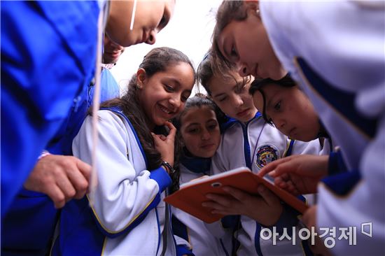 ▲삼성전자 콜롬비아법인 임직원들이 지난 4일 보고타 지역 중학교에서 학생들과 태블릿PC를 활용한 실습을 진행하고 있다.(제공=삼성)