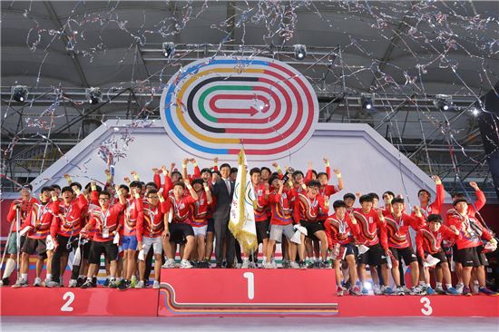 지난해 열린 '모두의 올림픽' 시상식에서 이창엽 한국 코카-콜라 대표이사(가운데 깃발)와 1,2,3등 한 학교 학생들이 수상 후 기념 촬영을 하고 있다.