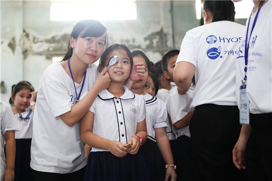 ▲효성 '미소원정대'가 지난해 11월 베트남 호치민시 인근의 초등학교를 방문해 현지 어린이들의 기초 건강검진을 진행하고 있다.
