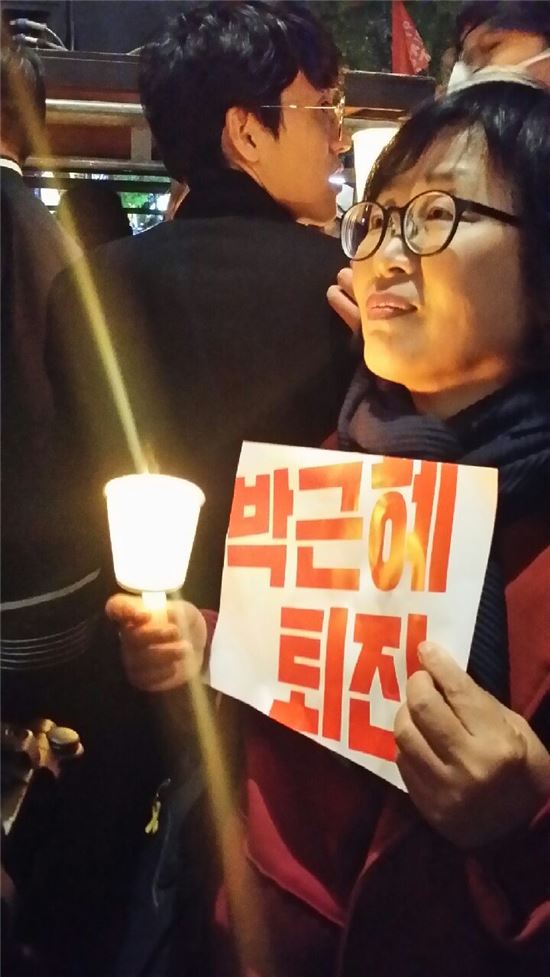한 시민이 박근혜 퇴진 피켓과 촛불 시위를 벌이고 있다. 