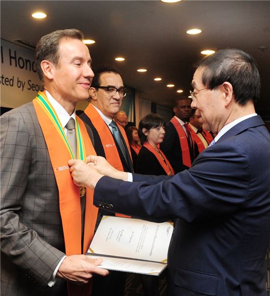 울프 아우스프룽 한성자동차 사장(왼쪽)이 박원순 서울시장으로부터 서울특별시 명예 시민 훈장을 받고 있다.