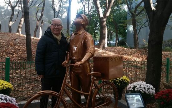 ▲김동화 작가가 자신의 작품 '빨간자전거' 캐릭터동상과 기념촬영을 하고 있다. 
