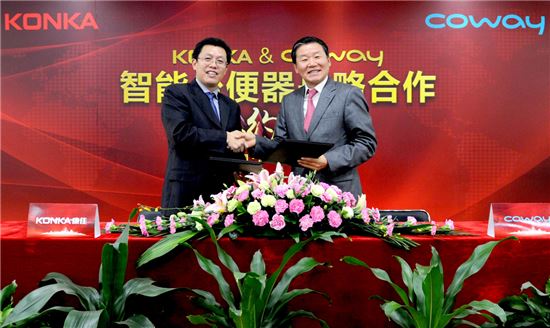 왼쪽부터 니우 웨이 둥 콩카 스마트가전 총재와 김용성 코웨이 해외사업본부장이 3일 중국 심천에서 업무협약을 체결하고 기념촬영을 하고 있다. 