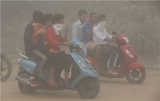 ▲스모그가 자욱한 뉴델리 시내를 오토바이를 타고 달리고 있는 시민들. (EPA=연합뉴스)