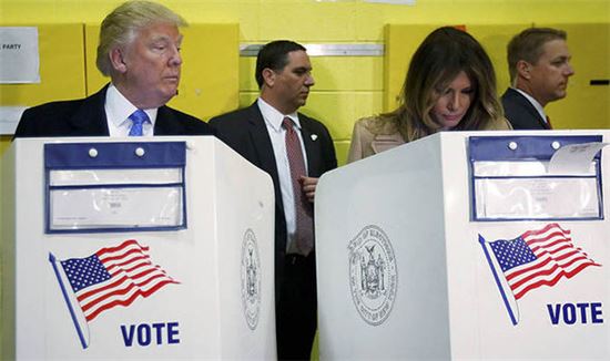 8일(현지시간) 오전 11시쯤 뉴욕 맨해튼의 공립학교에 마련된 투표소에서 투표 중인 도널드 트럼프 공화당 대선 후보가 아내인 멜라니아 트럼프의 투표용지를 쳐다보고 있다. (사진출처=AP) 