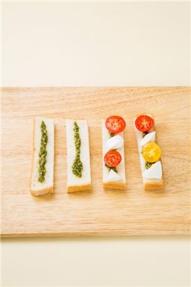 4. 식빵에 방울토마토와 생모짜랠라 치즈를 얹고 바질을 올린다.