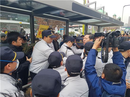 19일 서울역광장에서 열린 보수단체 집회에서 경찰이 "박근혜 하야" 외친 한 시민을 격리시키고 있다.