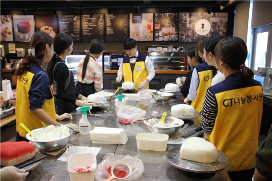 지난 19일 서울 금천구 가산동에 위치한 CJ푸드빌 아카데미에서 재능나눔 프로그램으로 열린 ‘행복나눔데이-커피&디저트교실’에 참석한 청소년들이 전문강사들과 함께 ‘투썸요거하트케이크’를 직접 만들고 있다. 