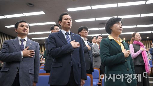 21일 박근혜 대통령 탄핵을 논의하기 위한 의원총회에 앞서 추미애 더불어민주당 대표(오른쪽)와 우상호 원내대표(가운데)가 국기에 대한 경례를 하고 있다. 