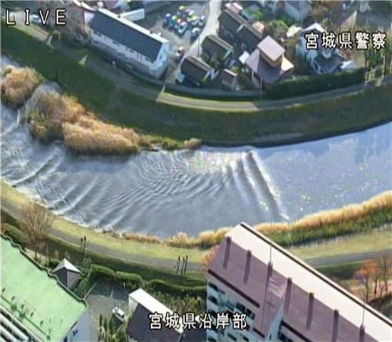 ▲미야기현 경찰이 공개한, 지진으로 인한 쓰나미가 강을 거슬러오르는 사진.  (AP=연합뉴스)