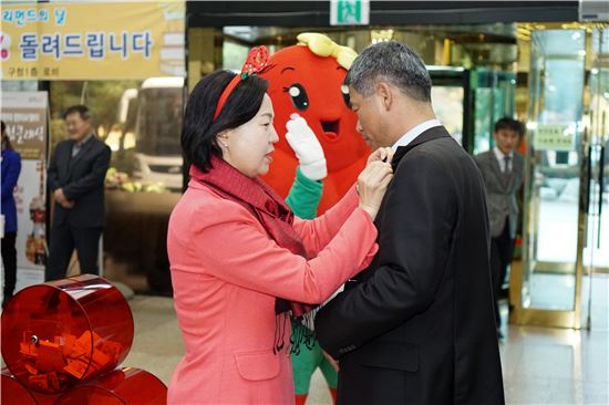 김수영 양천구청장이 지난해 사랑의 열매달기 캠페인 행사에서 사랑의 열매를 달아주고 있다.