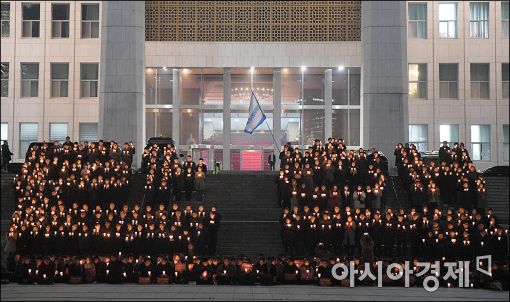 5일 더불어민주당이 국회 앞에서 박근혜 대통령의 퇴진을 요구하는 촛불을 들고 있다.
