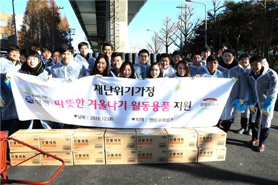 애경산업 임직원들이 6일 서울 영등포구에 위치한 쪽방촌에 월동용품을 전달한 뒤 기념촬영을 하고 있다. 