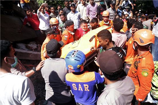 ▲7일(현지시간) 규모 6.5의 강진이 발생한 인도네시아 아체주에서 구조당국이 희생자의 시신을 실어나르고 있다. (사진=AP연합뉴스)