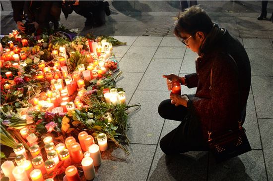 한 베를린 시민이 트럭 테러로 희생당한 이들의 넋을 위로하기 위한 촛볼을 켜고 있다.(사진=EPA연합)