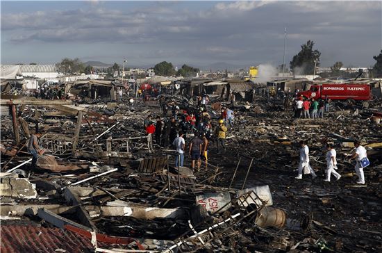 폭발 사로로 쑥대밭이 된 폭죽시장에서 감식반원들과 구조대원들이 현장을 살피고 있다.(사진=AP연합)