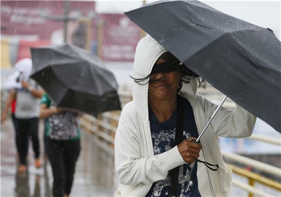 ▲우산을 쓰고 빗속을 걷고 있는 필리핀 파라냐케의 시민. (AP=연합뉴스)