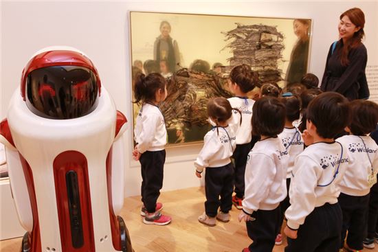 5일 오전 현대 어린이책 미술관에서 어린이들이 '로봇 도슨트 모모'에게 '그림+책+아트' 전시 설명을 듣고 있다. 
