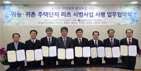 박상우 한국토지주택공사(LH) 사장(왼쪽 네번째)이 10일 경남 진주시 본사 사옥에서 아산시·홍천군·영월군·청양군·담양군·강진군·함양군 등 7개 시·군과 '귀농·귀촌주택 리츠 시범사업' 업무협약을 체결하고 기념촬영을 하고 있다.(제공: LH)
