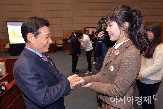 윤장현 광주광역시장이 18일 오후 광주시의회 본회의장에서 열린 '제1대 광주광역시 어린이·청소년의회’ 개원식에 참석해 청소년 의원에게 배지를 수여 한 뒤 악수를 나누고 있다./광주광역시 제공