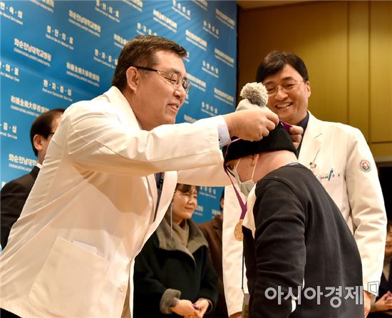 김형준 화순전남대병원장(왼쪽)과 소아청소년과 국훈 교수 등이  완치메달을 걸어주고 있다.