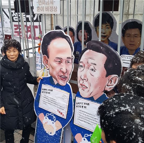 용산참사 8주기를 맞은 유가족들이 21일 서울 광화문광장에서 이명박 전 대통령과 김석기 새누리당 의원이 수갑을 차고 있는 모형을 만들어 '광화문 교도소'에 넣는 퍼포먼스를 하고 있다.
