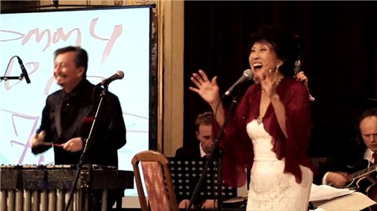 2013년 12월 헝가리 부다페스트에서 남편 토미 빅의 연주에 맞춰 노래를 부르는 김민자