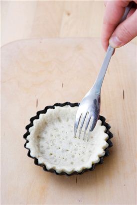 5. 반죽을 파이 틀 크기에 맞게 밀대로 밀어 파이 틀에 넣어 가장자리를 손가락으로 눌러주며 파이 틀과 밀착시킨 후 포크로 바닥을 찔러 구멍을 낸다.