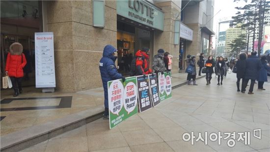 지난 10일 롯데백화점·롯데면세점 본점 앞에서 일부 시민들이 경북 성주 소재 롯데골프장을 사드 배치 부지로 제공하지 말라는 내용의 팻말을 들고 시위를 진행하고 있다. 팻말은 중국어로도 번역됐다. 