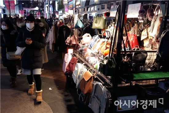 12일 저녁 서울 명동 거리. 외국인 관광객들이 옷·가방 노점상을 지나쳐 가고 있다.(사진=오종탁 기자)