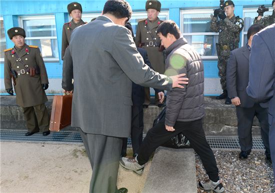18일 동해 상에서 기관 고장으로 표류 중 구조된 북한 선박에 타고 있던 선원이 판문점에서 북 측으로 넘어가고 있다.(제공: 통일부)