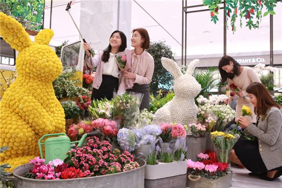 26일 현대백화점 판교점 1층 열린광장에서 고객들이 백화점에 먼저 찾아온 봄꽃을 즐기고 있다.
