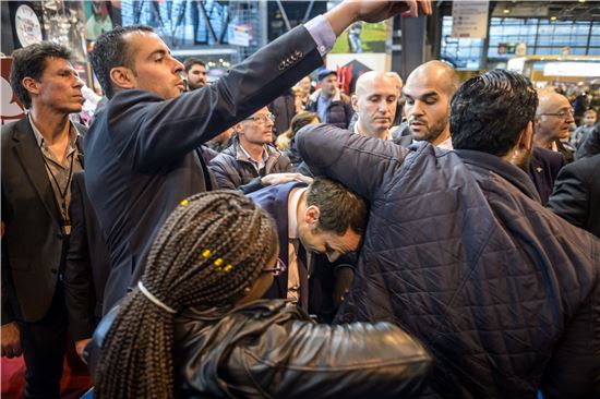 1일(현지시간) 프랑스 파리에서 열린 연례 농업박람회에서 에마뉘엘 마크롱 전 경제장관이 익명의 남성이 던진 계란에 맞은 얼굴을 숙이고 있다. (사진출처=EPA연합)