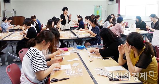 광산구 수완보건지소가 지난해 5월 진행한 행복플러스 임신·출산·육아관리 프로그램에 참가한 주민들이 신생아 모자 등 육아용품을 만들고 있다.