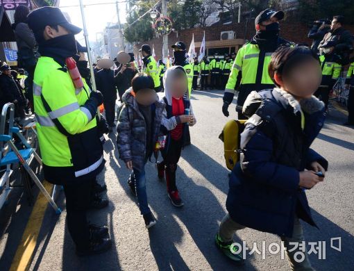 14일 서울 강남구 박근혜 전 대통령 사저 인근의 초등학교 학생들이 경찰이 만든 질서유지선을 따라 지나가고 있다.(사진= 백소아 기자)
