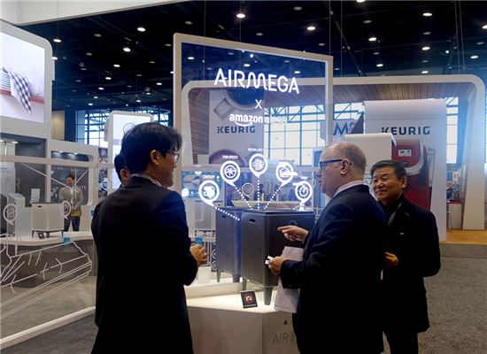 김용성 코웨이 해외사업본부장(오른쪽 첫 번째)과 해외 바이어 등이 공기청정기 '에어메가' 제품에 대해 이야기를 나누고 있다.

