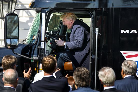 도널드 트럼프 미국 대통령이 23일(현지시간) 트럭 산업 관계자들과의 회동을 앞두고 트럭에 올라 운전하는 듯한 모습을 취해보이고 있다. (사진=EPA연합)