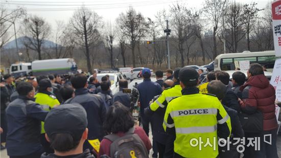 황창규 회장이 자신의 연임을 반대하는 이들의 저지를 뿌리치고 주주총회장 밖으로 나서고 있다. 이날 주주총회장에는 물리적 충돌에 대비, 10명이 넘는 경찰이 오전부터 배치됐다.