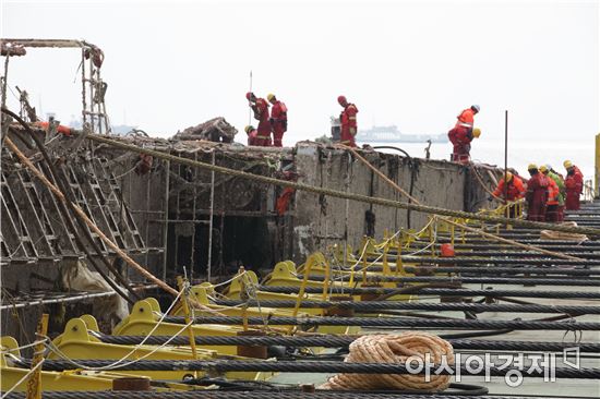 24일 상하이샐비지 작업자들이 세월호 선체를 잭킹바지선에 결박하고 있다.(사진:해양수산부)