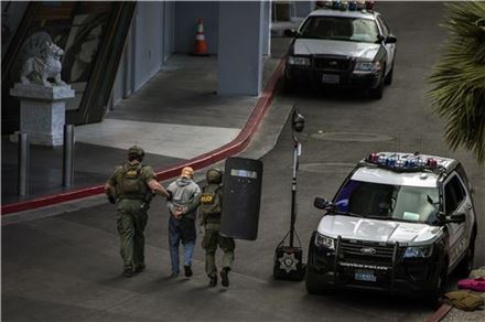 25일(현지시간) 미국 라스베이거스에서 발생한 총격 사건 용의자 중 1명이 체포돼 연행되고 있다. (사진=AP연합)