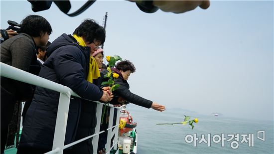 28일 서해어업관리단 소속 무궁화 5호 선상에서 열린 세월호 미수습자 수습을 기원하기 위한 종교행사에서 미수습자 가족들이 바다 위로 꽃을 띄우고 있다.