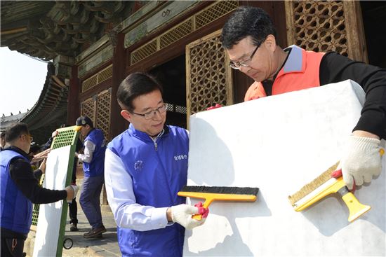 삼성물산 리조트부문 김봉영 사장(좌)과 박정상 창경궁 관리소장(우)이 국보 226호로 지정된 창경궁 명정전의 오래된 창호지를 교체하는 모습

