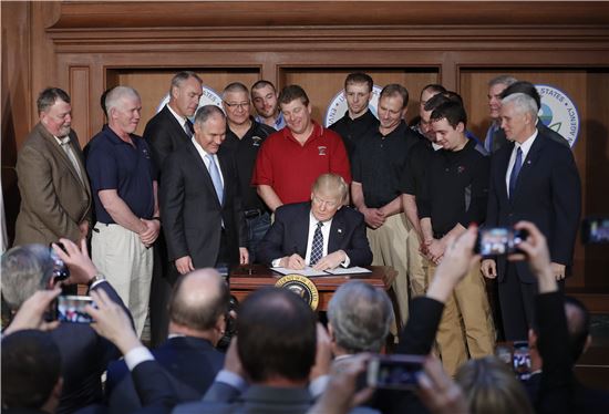도널드 트럼프 미국 대통령이 28일(현지시간) 광산 노동자들이 지켜보는 가운데 에너지 독립 행정명령에 서명하고 있다.(사진=AP연합)