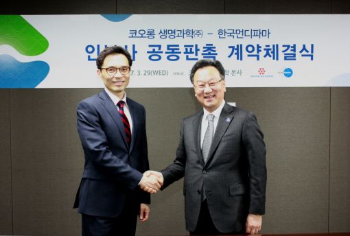 이우석 코오롱생명과학 대표(오른쪽)와 이명세 한국먼디파마 사장이 인보사 관련 전략적 파트너십 협약을 맺고 악수를 나누고  있다.