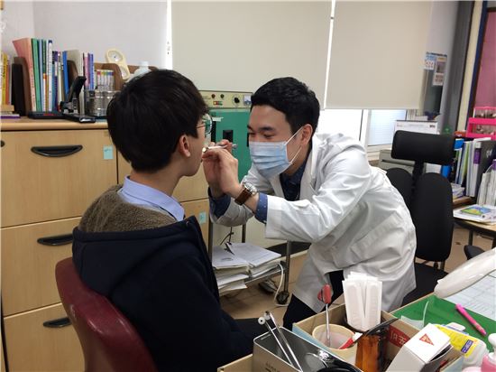 서울 최초의 남자 보건교사 김찬현씨가 학생들을 진료하고 있다(사진=서울시교육청)